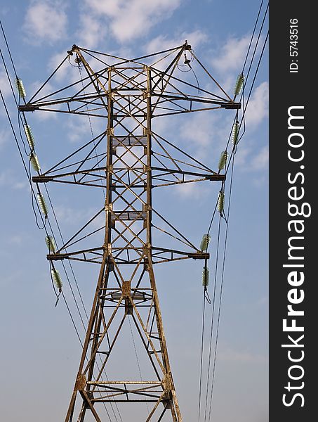 Power transmission pole against blue sky, view from below