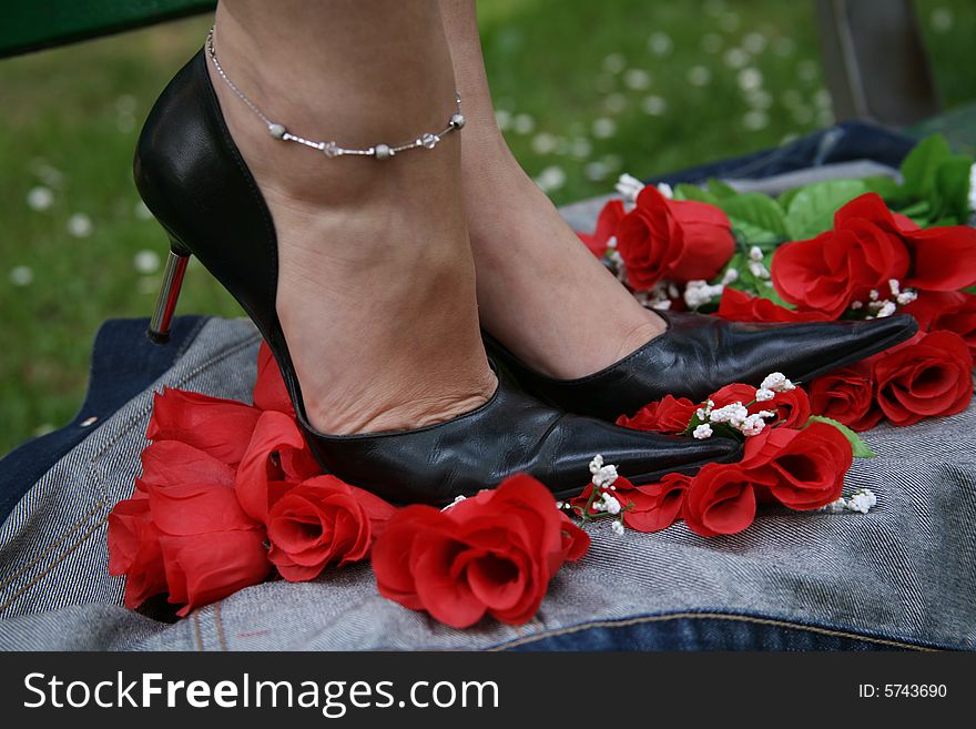 Female feet dressed in fashion shoes and socks, crushing roses. Female feet dressed in fashion shoes and socks, crushing roses.