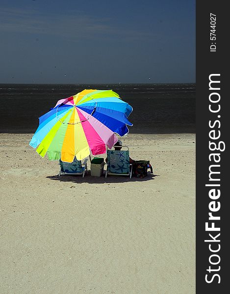 Woman sitting under colorful umbrella