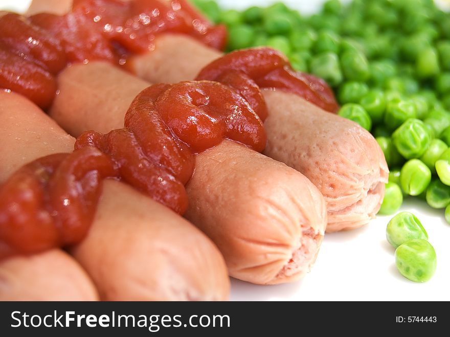 Sausage with green peas on a plate