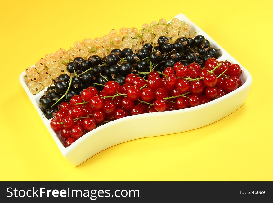 Bowl of currants on a yellow background. Bowl of currants on a yellow background.