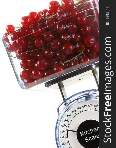 Kitchen scales and red currants on a white background. Kitchen scales and red currants on a white background.