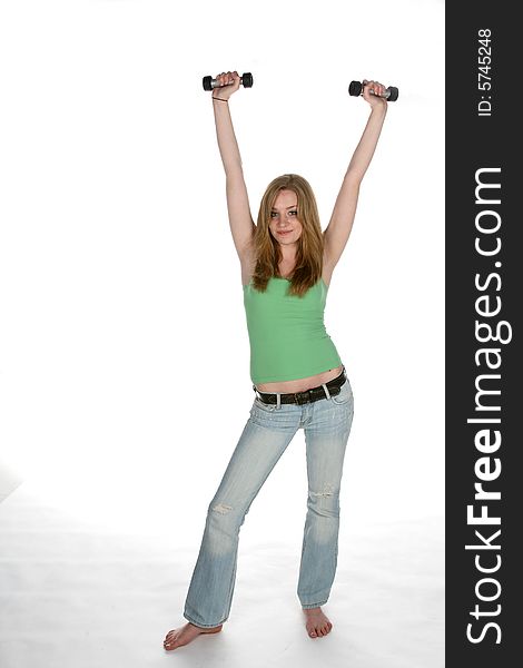 Young woman in green lifting barbells up high. Young woman in green lifting barbells up high