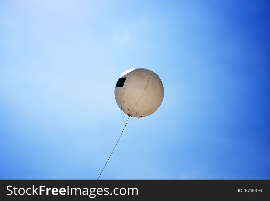 A balloon raise up to blue sky on sunny day.