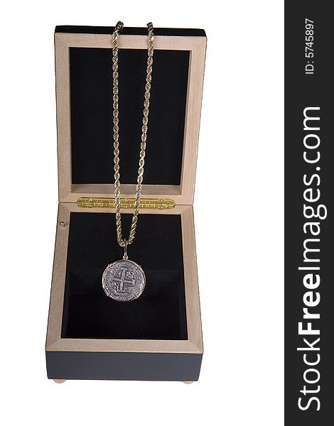 An old coin on a gold chain in a display box. An old coin on a gold chain in a display box