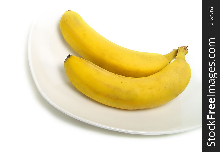 A bunch of fresh bananas on white plate and isolated on white background. A bunch of fresh bananas on white plate and isolated on white background