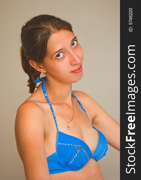 The young and very attractive girl dressed in a blue bathing suit