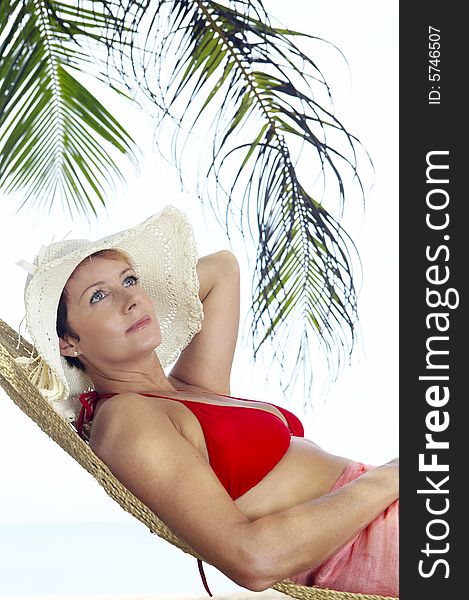 View of nice woman lounging in hammock in tropical environment