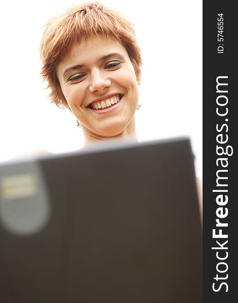 Young woman smiles and working on laptop