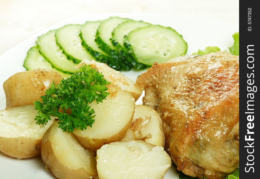 Roasted chicken with potatoes and cucumbers. Roasted chicken with potatoes and cucumbers
