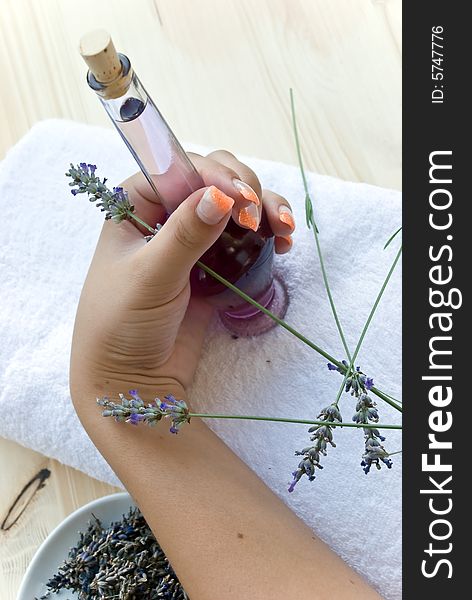 Lavender oil bottle and woman hand.