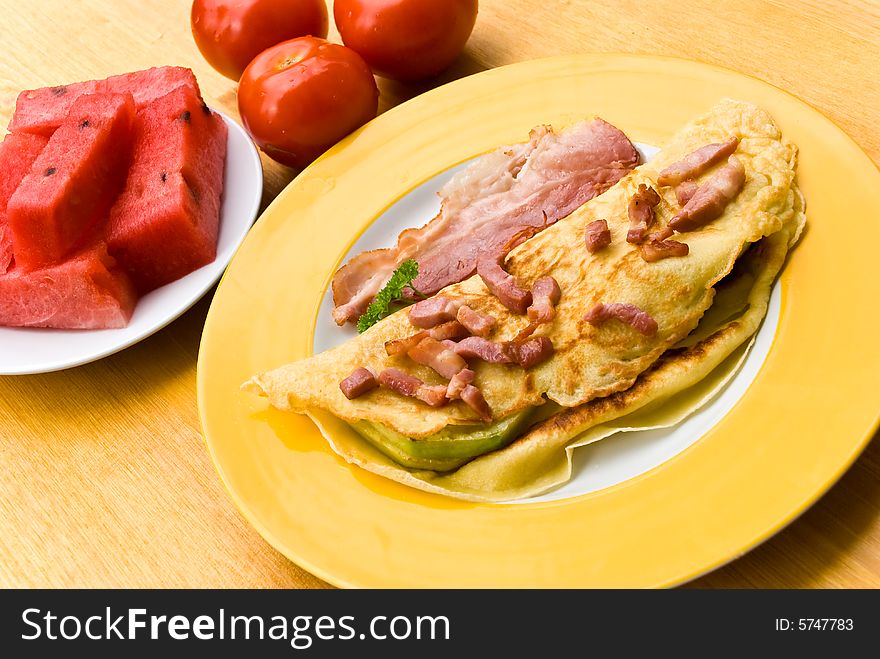 Fried eggs with bacon,melon and tomato.
