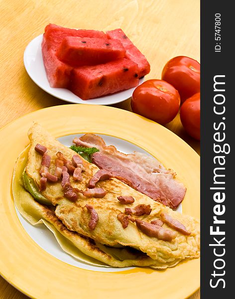 Fried eggs with bacon,melon and tomato.