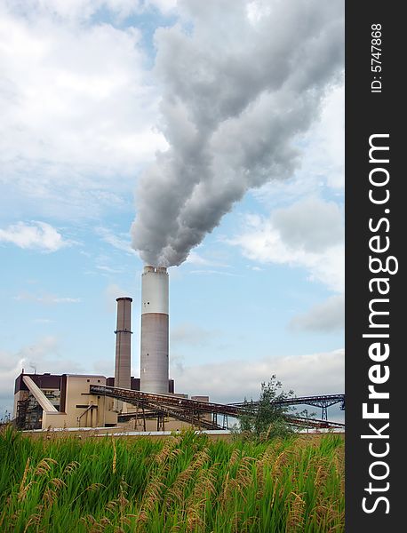 Smoke billiowing out of the large smoke stack at a power plant. Smoke billiowing out of the large smoke stack at a power plant.