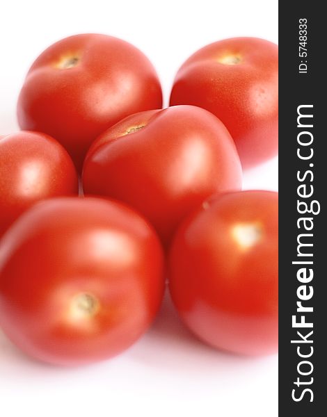 Six fresh, ripe tomatoes, arranged on a white background. Six fresh, ripe tomatoes, arranged on a white background
