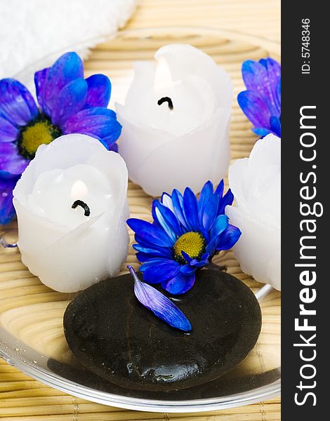 Candles in water with blue flowers and towel. Candles in water with blue flowers and towel