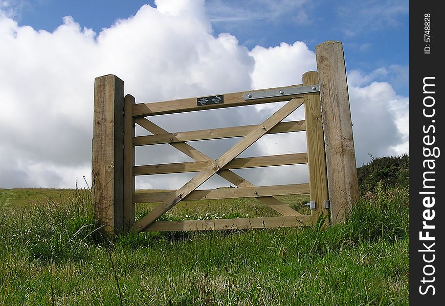 A five-barred gate stands in a field on its own, with no fence around it.  The grass is green and the sky is blue with some big billowing white clouds.  The walker is free to pass either side, he has freedom to choose. A five-barred gate stands in a field on its own, with no fence around it.  The grass is green and the sky is blue with some big billowing white clouds.  The walker is free to pass either side, he has freedom to choose.