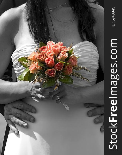 Bride's holding her coral rose bouquet. Bride's holding her coral rose bouquet