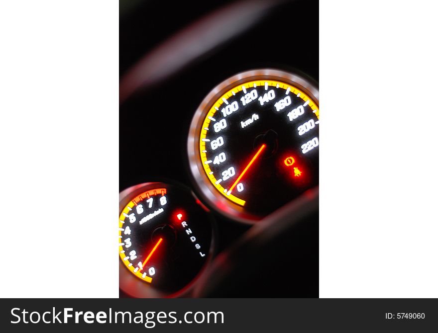 The picture of a illuminating speedometer that is glowing.