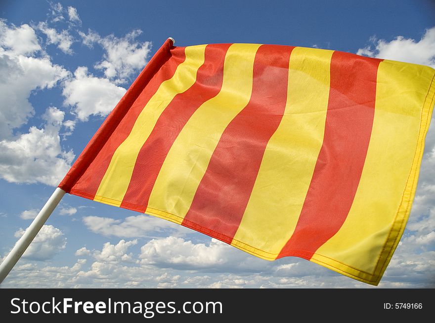 Yellow flag on a background of the dark blue sky with clouds. Yellow flag on a background of the dark blue sky with clouds.