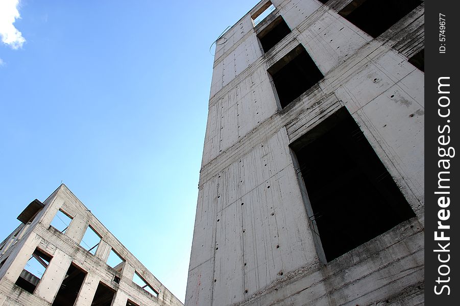 Two unfinished gray buildings with sky. Two unfinished gray buildings with sky