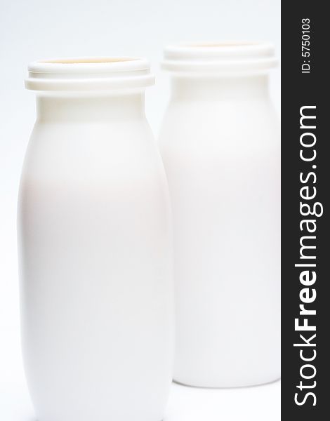 Two jars with milk over white