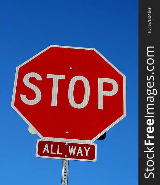 A stop sign in front of a blue sky.