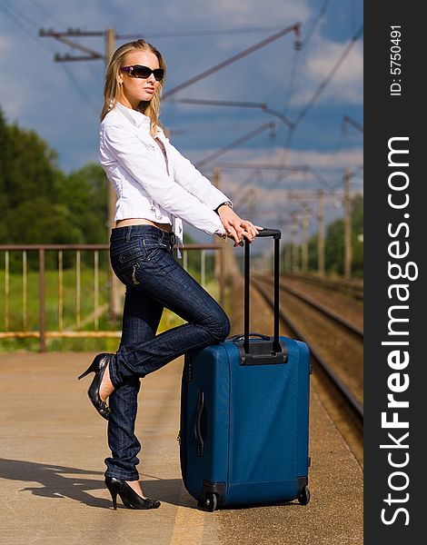 Beautiful young lady with luggage waiting for a train. Beautiful young lady with luggage waiting for a train