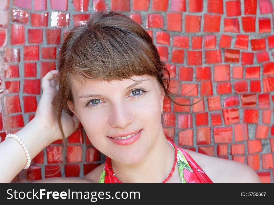 Beautiful woman posing for the camera with emotions against red wall