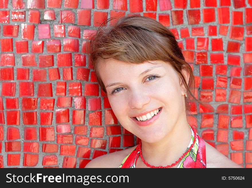 Beautiful woman posing for the camera  with emotions against red wall