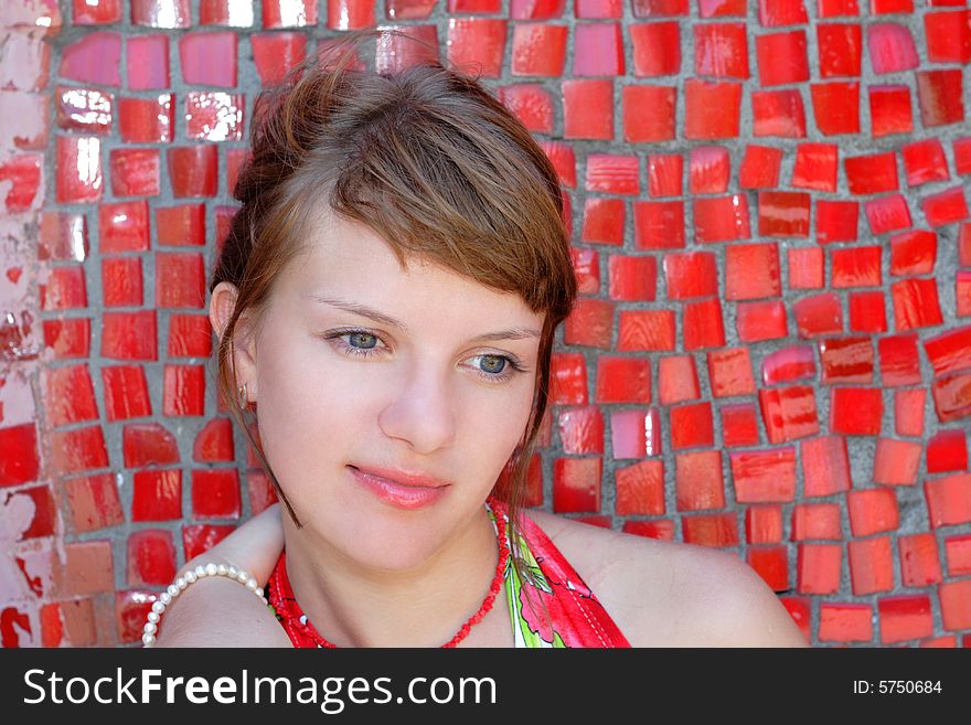 Beautiful woman posing for the camera  with emotions against red wall