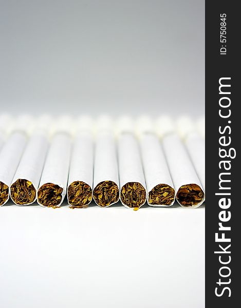 Cigarettes arranged in line on a white background. Cigarettes arranged in line on a white background