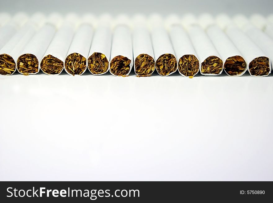 Cigarettes laying in line on a white background. Cigarettes laying in line on a white background
