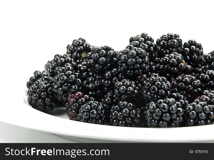 Blackberry on the plate , isolated on white.