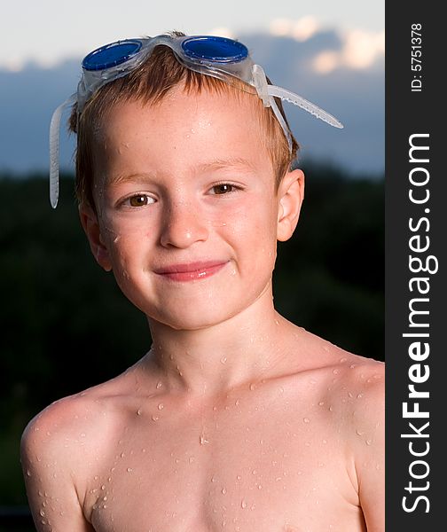 A happy boy with goggles finishes swimming. A happy boy with goggles finishes swimming