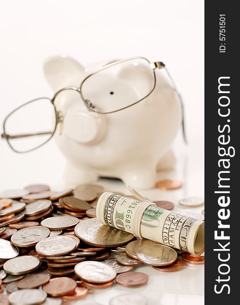 US coins and currency and blur piggy bank wearing glass background