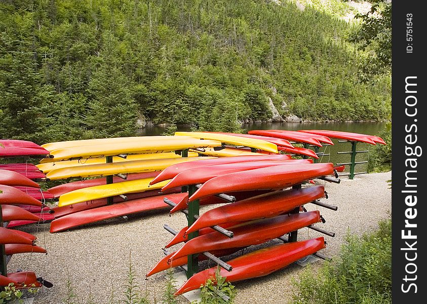 A bunch of yellow and red stacked kayaks