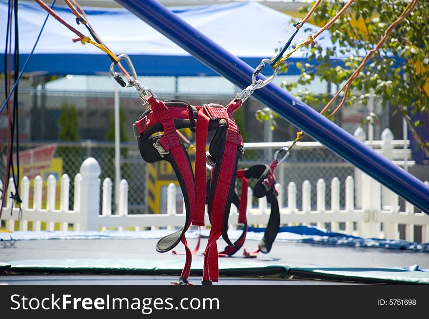 The harness for a trampoline spot support system with trampoline below and circus tent behind. The harness for a trampoline spot support system with trampoline below and circus tent behind.