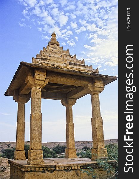 Carved in yellow sandstone this cenotaph is constructed with four pillars supporting a square roof in memoriam of an ancient ruler of the rich city of Jaisalmer, Rajasthan, India. Carved in yellow sandstone this cenotaph is constructed with four pillars supporting a square roof in memoriam of an ancient ruler of the rich city of Jaisalmer, Rajasthan, India.