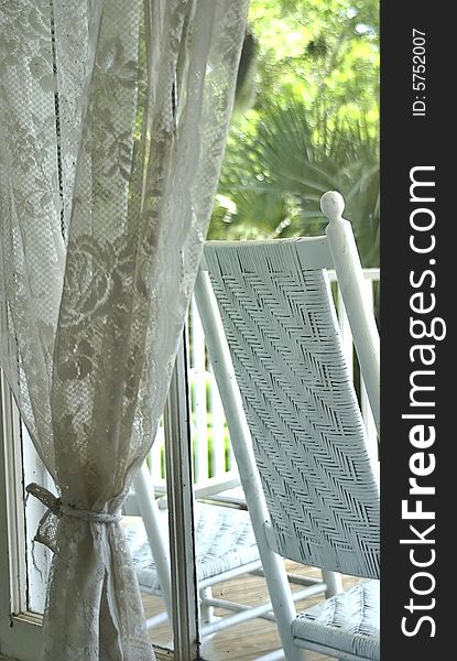 A peaceful image of window lace and rocking chair.