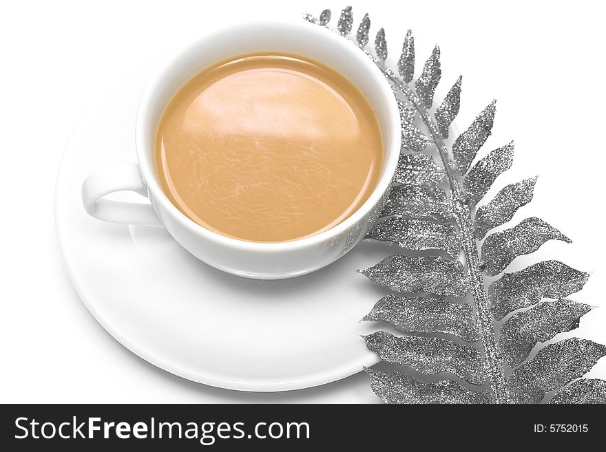 White cup of coffee with silver leaf