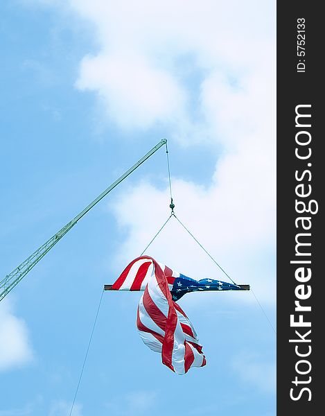 A crane suspending an American flag on the fourth of July.