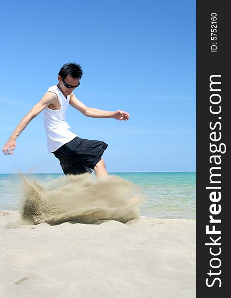 Man kicking the tropical beach sand