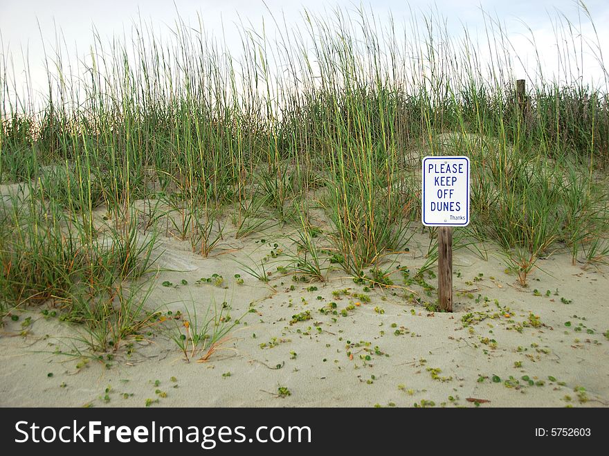 A prohibitory sign on a sand dune. A prohibitory sign on a sand dune.