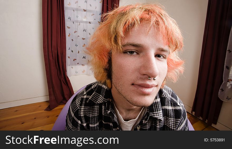 Closeup of a Young man with Bright Hair in a Bare Room