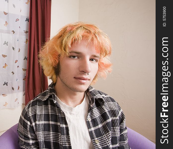 Closeup of a Young man with Bright Hair in a Bare Room