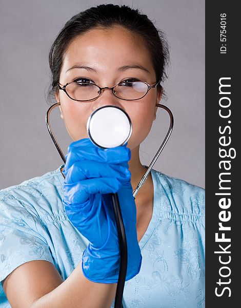 Health care young nurse pointing a stethoscope.