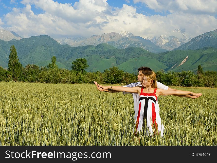 Young married couple in a wheat field, woman is pregnant. Young married couple in a wheat field, woman is pregnant