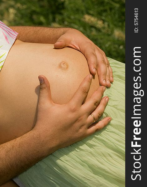 Close-up of belly of pregnant woman with her husband hands. Close-up of belly of pregnant woman with her husband hands