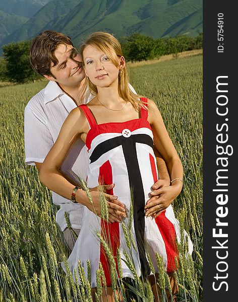 Young married couple in a wheat field, woman is pregnant. Young married couple in a wheat field, woman is pregnant